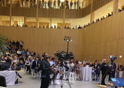 Large event space with audience and two cameramen